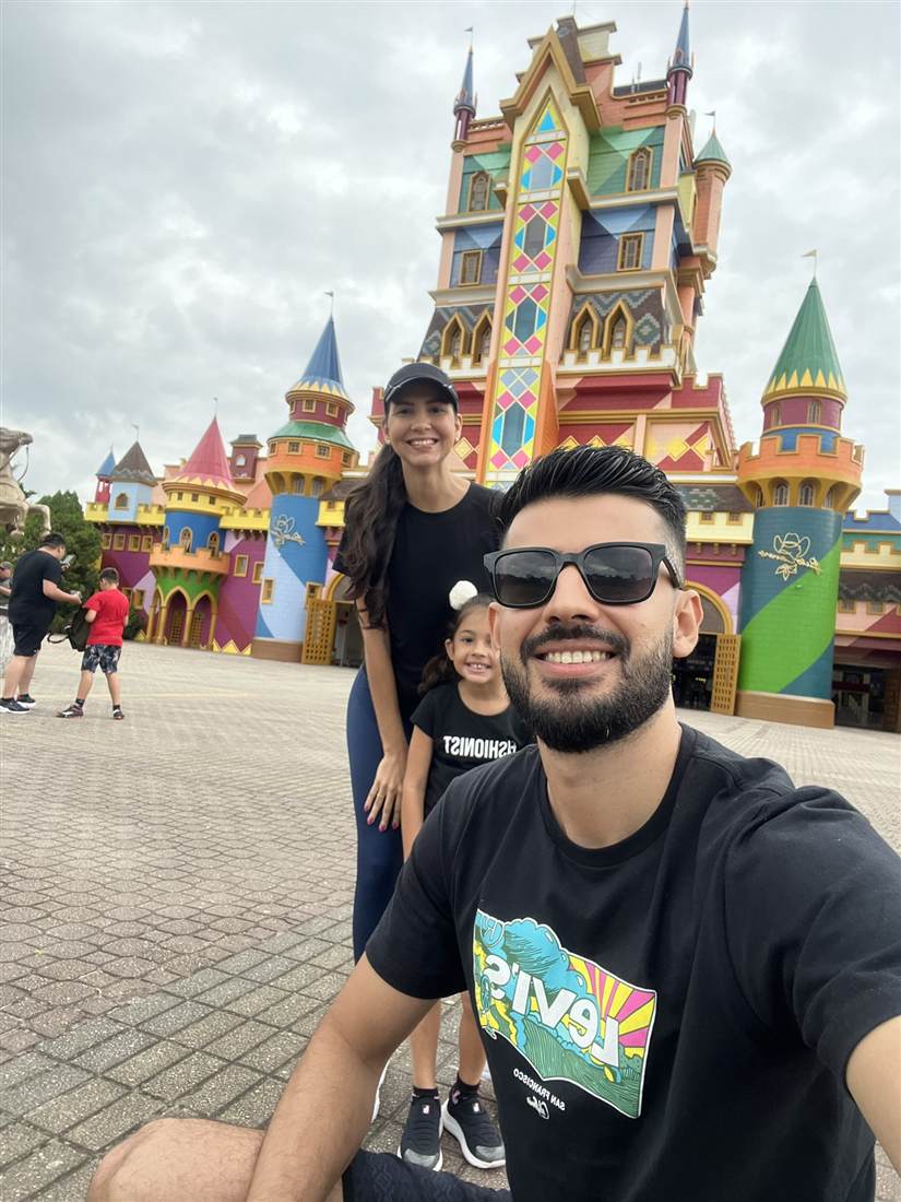 Sergio, a mulher e a filha sorrindo em frente ao castelo do parque Beto Carrero World