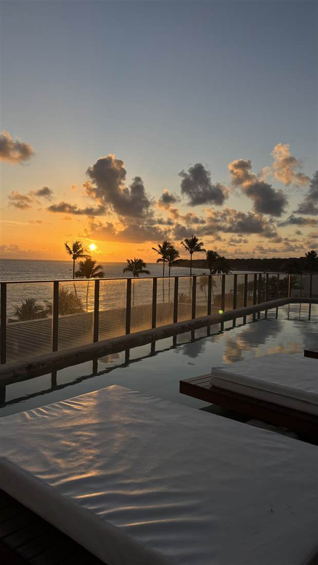 Pôr do sol visto de uma piscina de hotel em João Pessoa